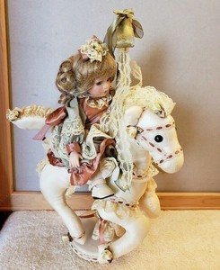 porcelain doll on carousel horse