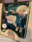 1985 calico cabbage patch twins blonde hair blue eyes two dimples holding a cray