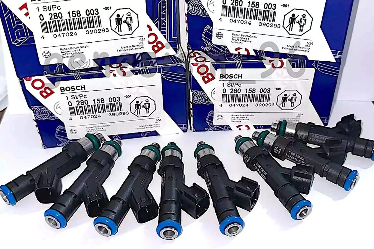 Eight Bosch fuel injectors and packaging, displayed on a white surface.