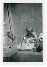 Kleiner Junge wäscht Wäsche auf dem Waschbrett Vintage um 1930