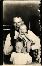 RPPC Man holding adorable baby and cute girl standing in front CYKO 1904-1920s