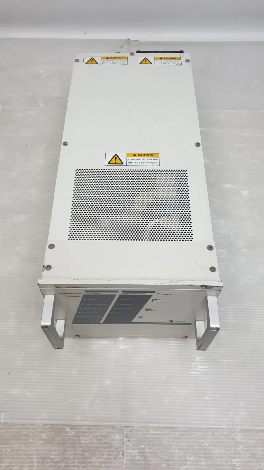 Top view of the Shimadzu EI-3203MD controller case with vent grille and caution labels