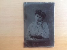 A genuine tintype of a woman striking a bizarrely posed portrait — a tiny 19th-century mystery you can hold in your hand.