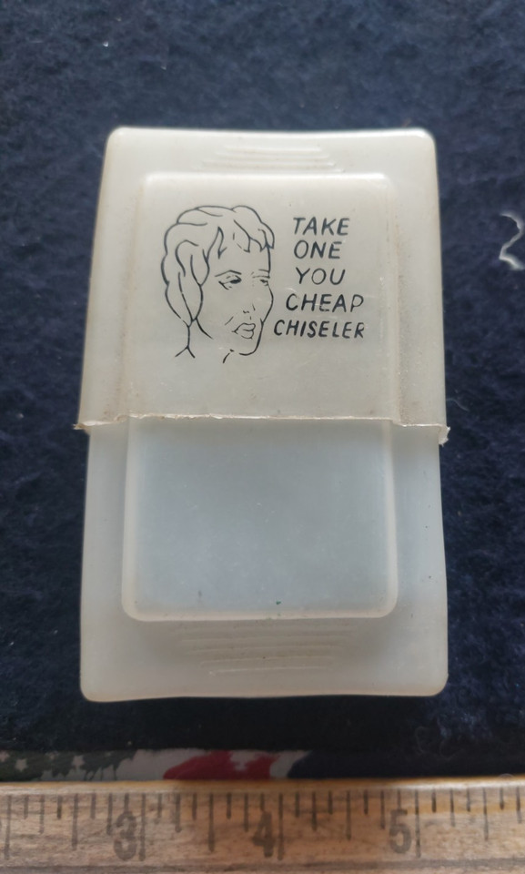 A snarky vintage cigarette case with built-in match holder and the gloriously rude inscription 'Take one you cheap chiseler' — instant conversation starter.
