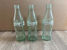 3 1986 Coca-Cola 8-ounce glass bottles