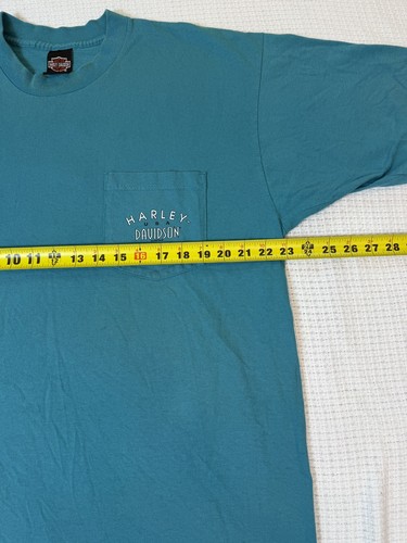 Teal Harley-Davidson men’s XL T-shirt with front pocket, yellow measuring tape, and white “Harley-Davidson Made in USA” text.