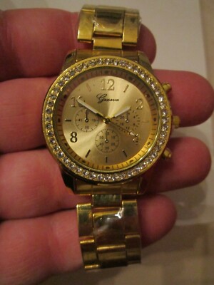 GENEVA GOLD TONE WATCH WITH CRYSTALS ON THE BEZEL - BBA-38