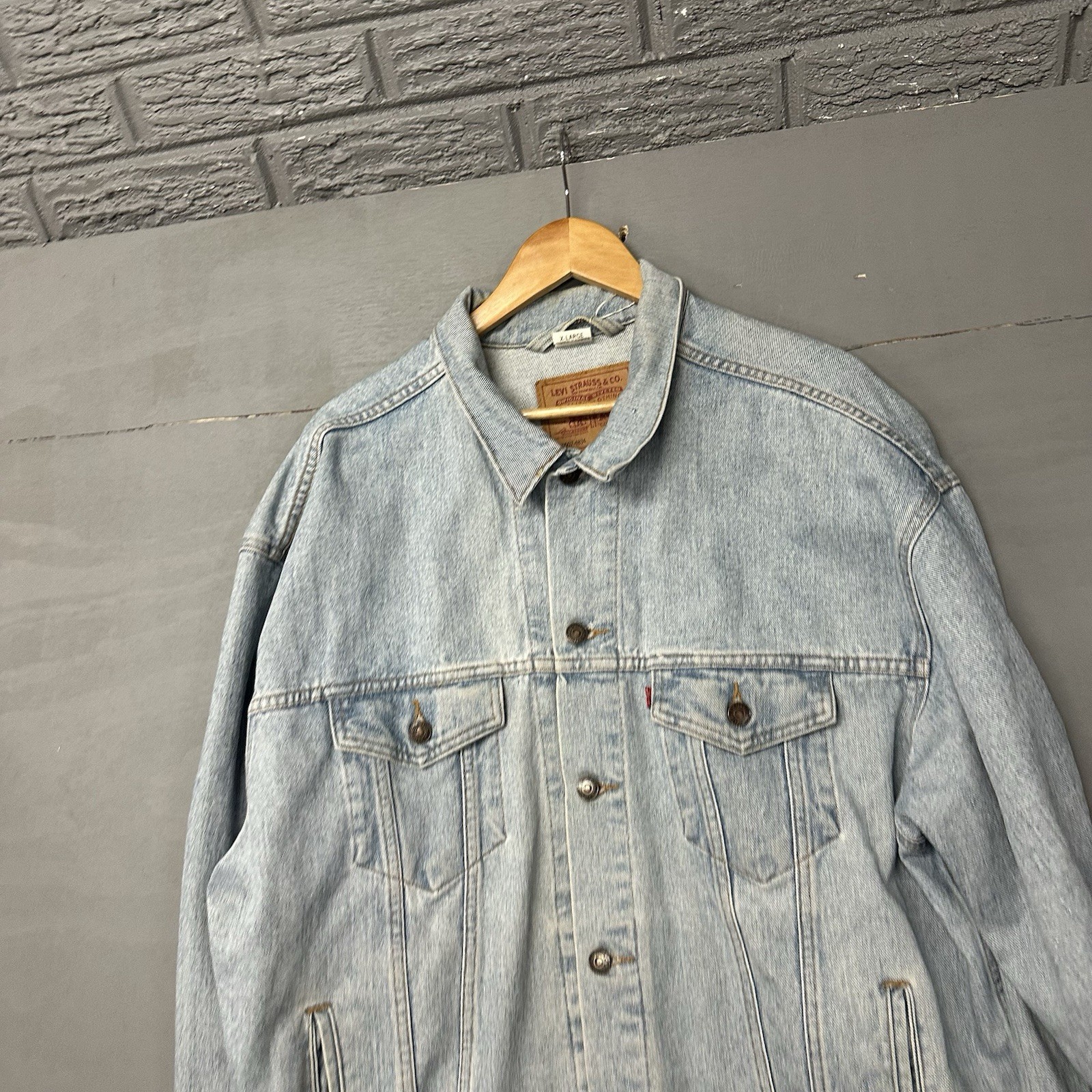 Faded blue Levi's denim trucker jacket with an acid-wash finish