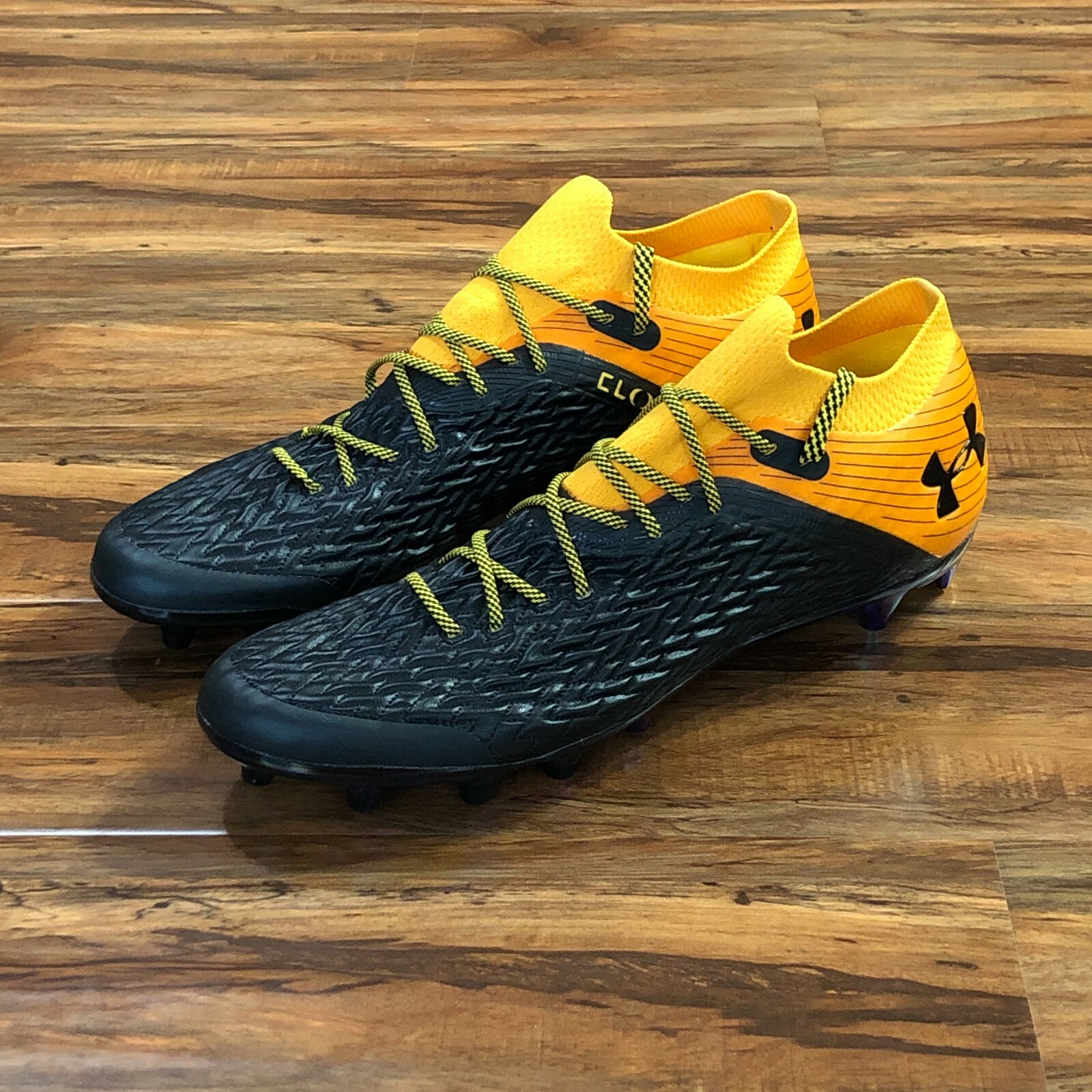 orange and white under armour cleats