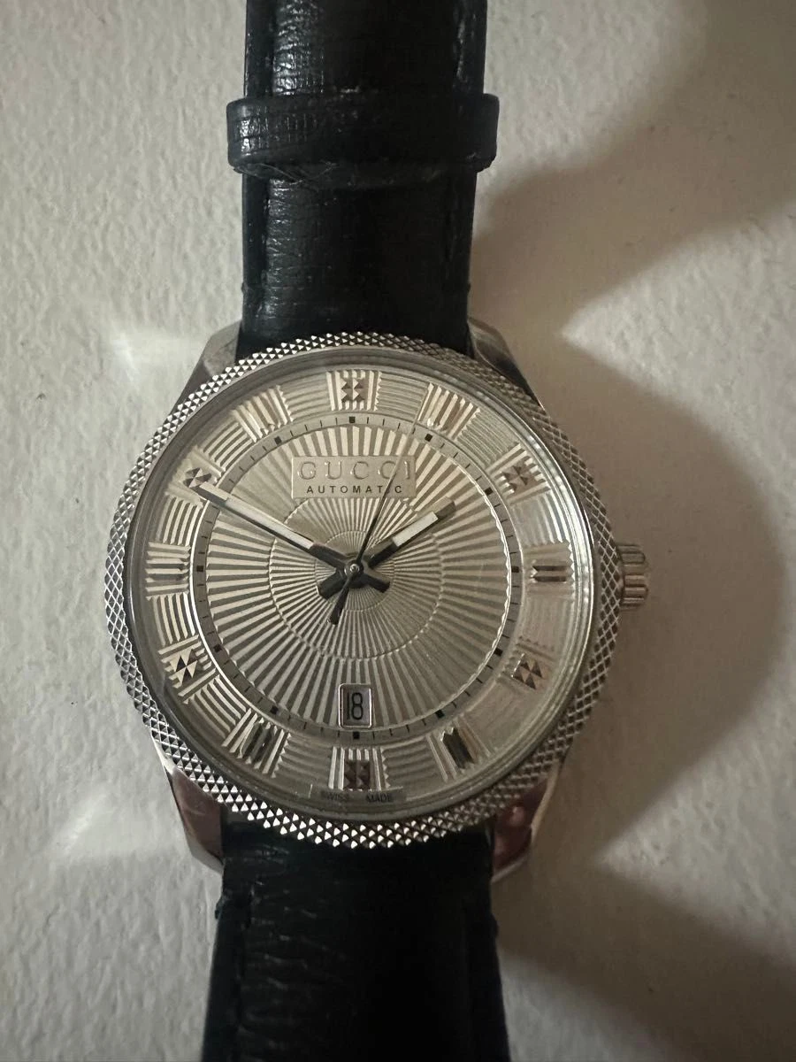 Automatic watch with silver striped dial and leather belt. GUCCI
