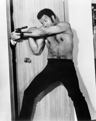Fred Williamson thwarts a gunman in a scene from one of his films - Old Photo
