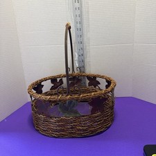 woven wicker basket with a metal handle and decorative metal leaf accents Unmark