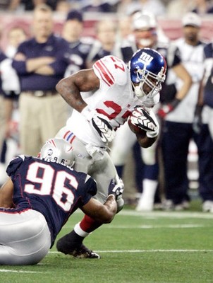 Giants Brandon Jacobs runs the ball while Pats Adalius Thomas duri- Old Photo