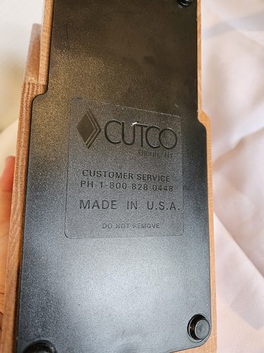 Brown woodgrain base of CUTCO Solid Honey Oak knife storage block with black text reading “Customer Service” and “Made in U.S.A.”