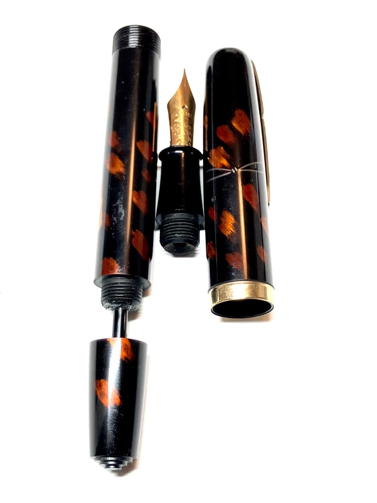 Vintage ink shut off fountain pen with brown and black urushi maki-e body, black tip, and gold-toned screw cap.