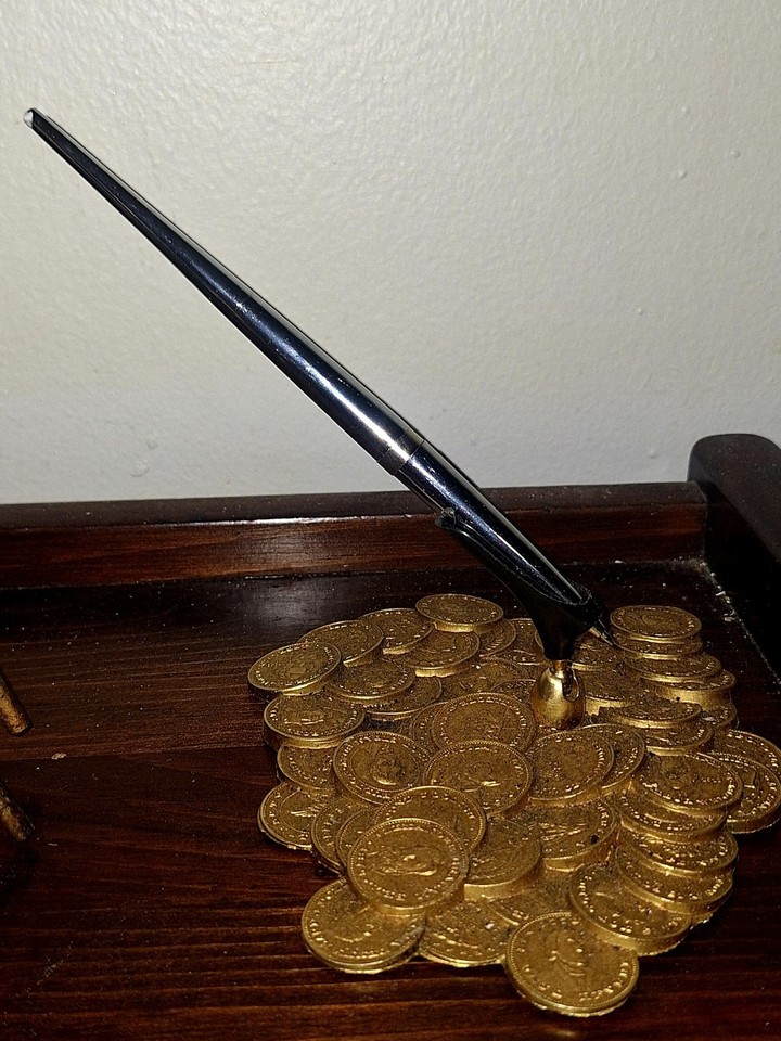 A kitschy 'Pile O Gold' coin-themed pen holder that's pure retro novelty — part desk accessory, part conversation piece.