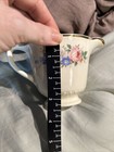 Cream ceramic mug with gold rim, floral print in pink and blue, and “Made in U.S.A.” text on porcelain body.