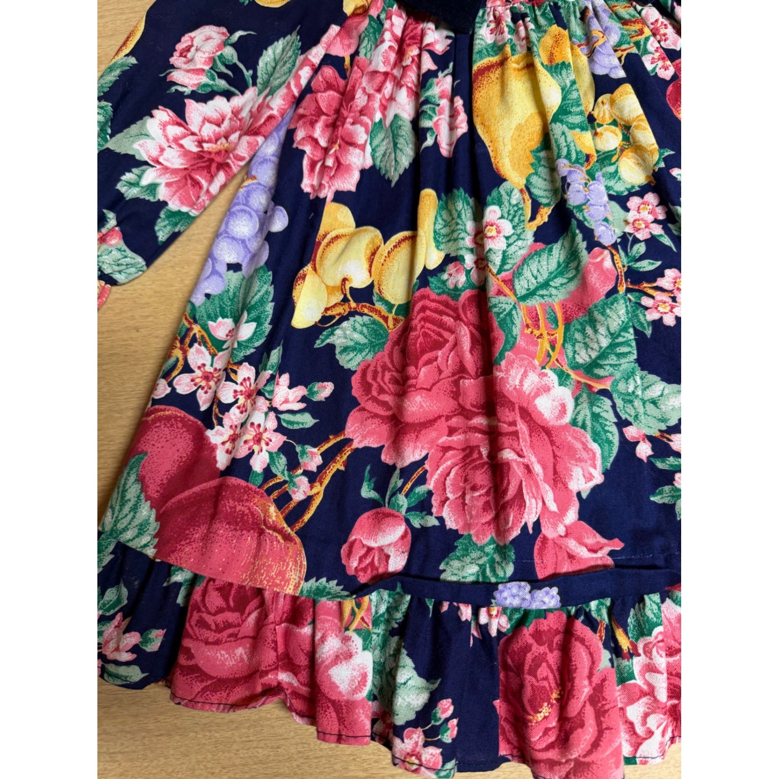 Navy velvet dress with pink and red floral print, green leaves, and ruffle hem, made in USA.