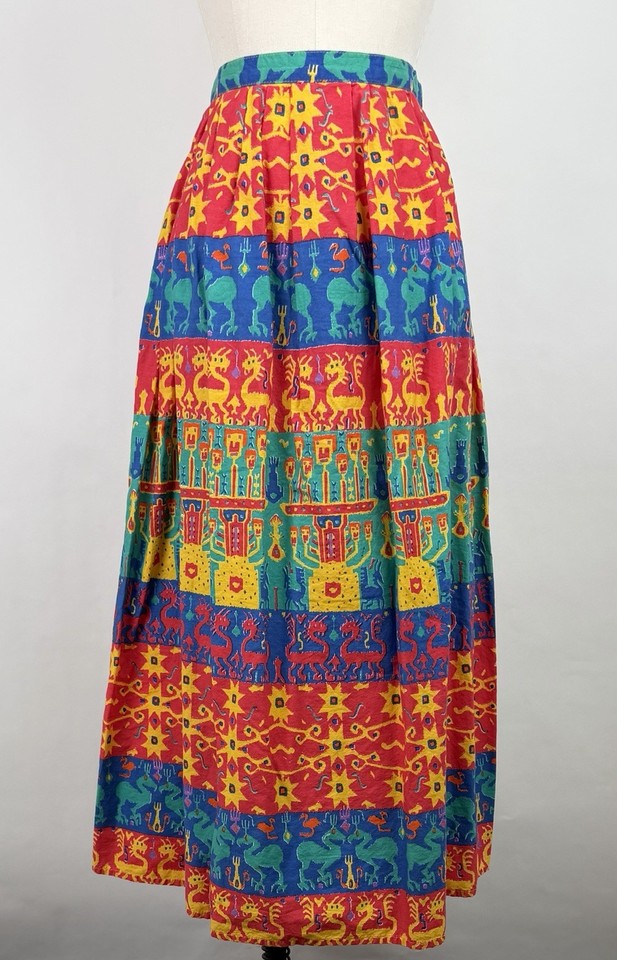 An 80s art-to-wear pleated maxi skirt with a bold colorful novelty print — wearable art that's instantly a conversation piece.