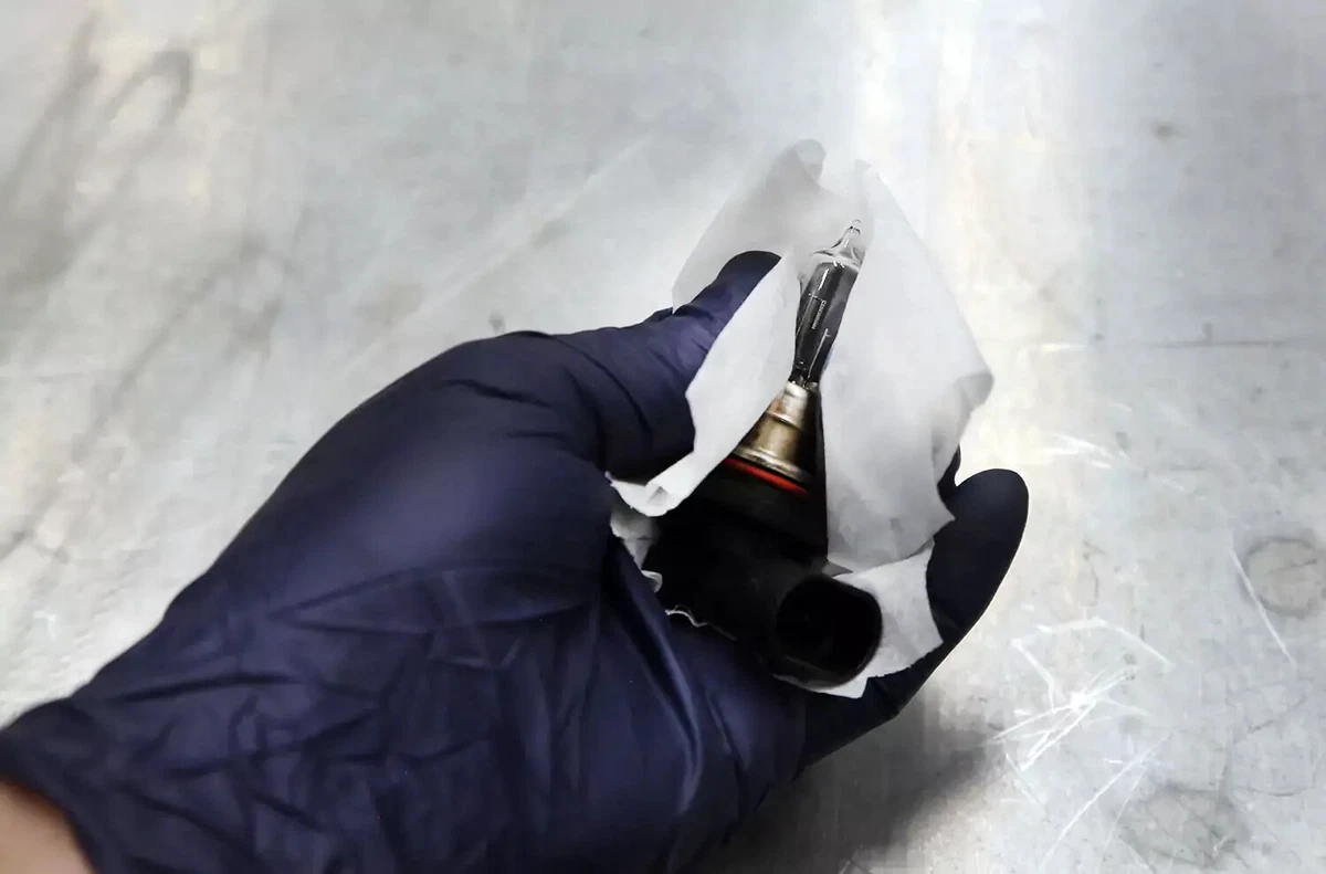 Cleaning a new car headlight bulb.