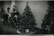 1991 Press Photo Nancy Witte vacuums up tree needles at the Festival of Trees