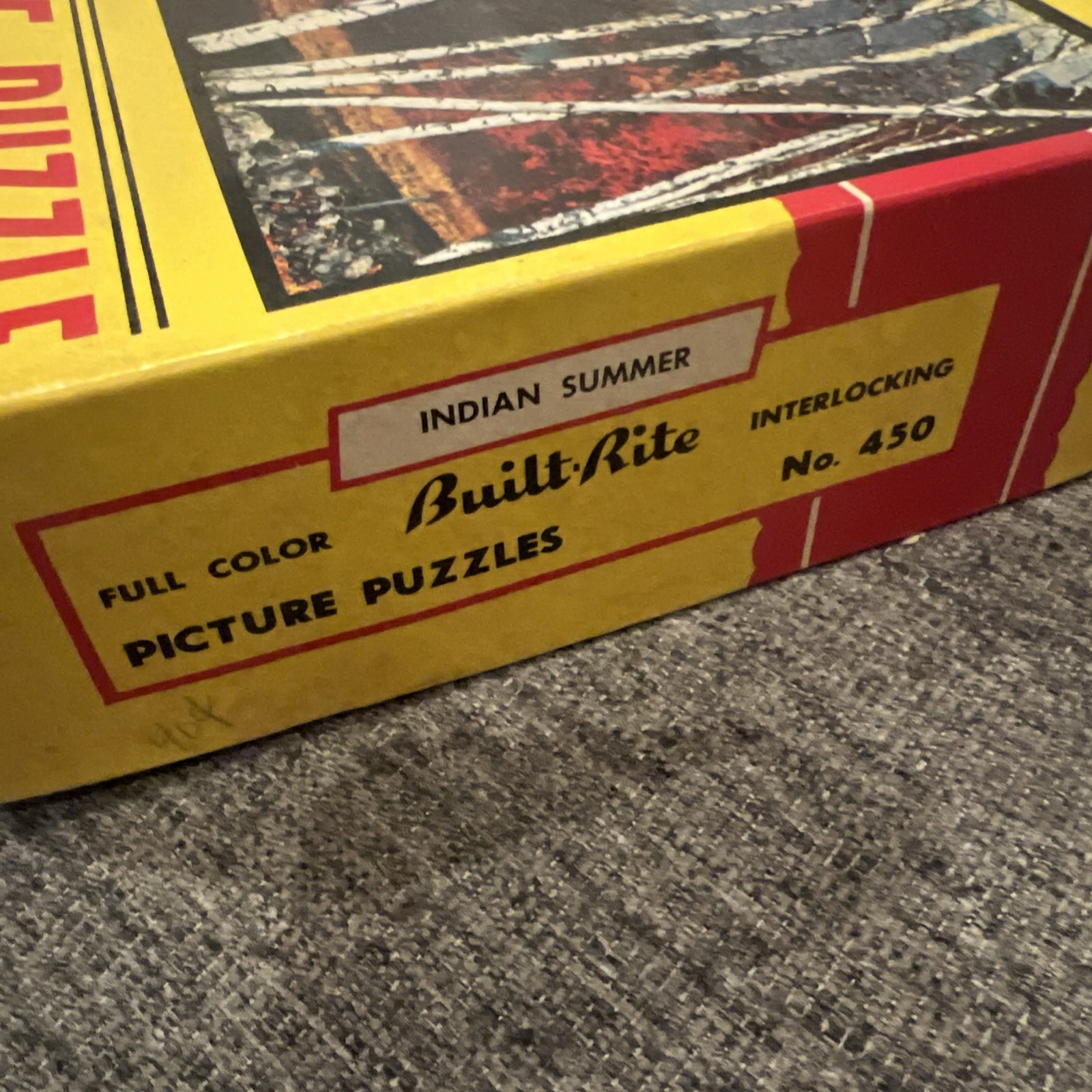 Yellow Built Rite box with red text “Indian Summer,” interlocking line art, and “No. 450” on wooden surface.