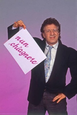 Italian singer Peppino di Capri smiles while holding a sign readin- Old Photo 1