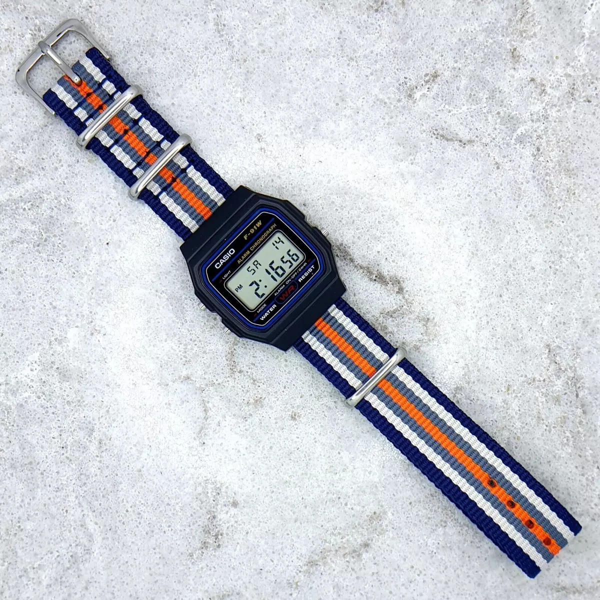 Casio F-91 Watch (Light Blue) on an Orange Nylon Strap