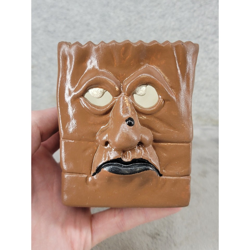 A grinning ceramic bag-face character that straddles the line between charming kitsch and outsider art — the kind of thing you'd hunt for at an estate sale for years.