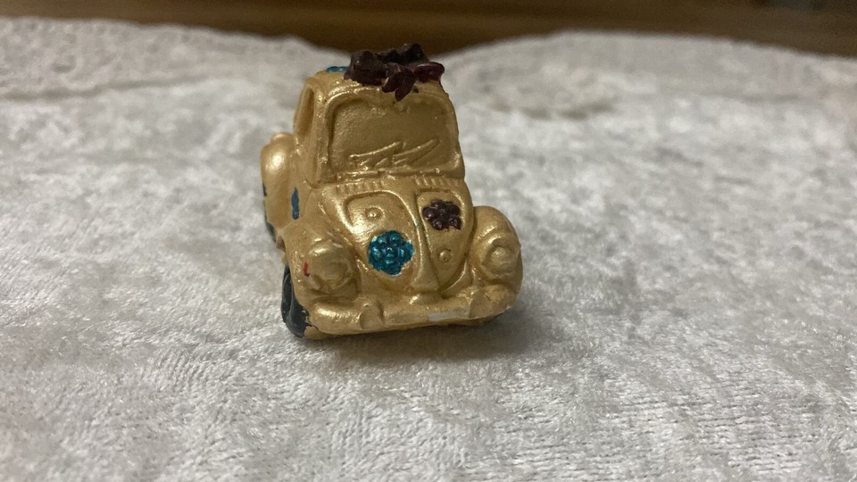 A tiny die-cast or resin Beetle figurine with retro design charm — the kind of desk tchotchke that sparks a whole conversation.