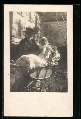 Photo postcard mother lifts her child out of the stroller 