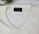 White V-neck Christian Dior men's sweater with blue text reading “100% Cotton Made in U.S.A.” on collar.