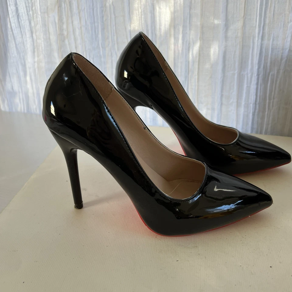 Zapatos de tacón alto con punta de aguja de charol negro parte inferior roja Foto 4 de 4