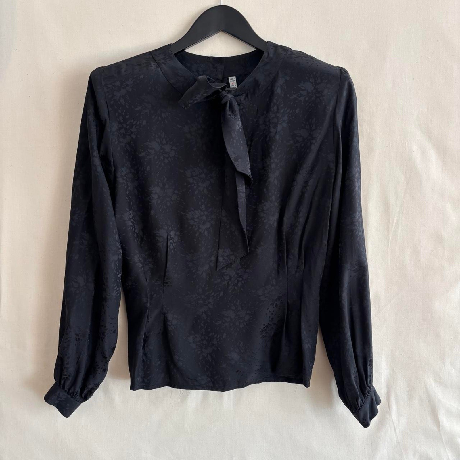 Black silk jacquard blouse with pussy-bow tie neck.