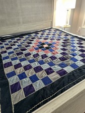 Handmade patchwork quilt featuring blue, purple, and pink fabric squares