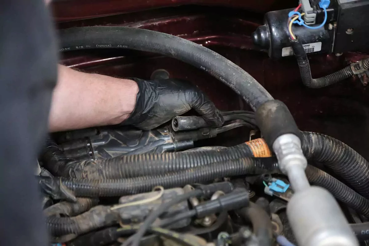 A mechanic removes a spark plug wire from the distributor cap.