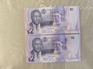 Belize 2 billets de two dollars numeros suiven risque déchirure pliure etc..