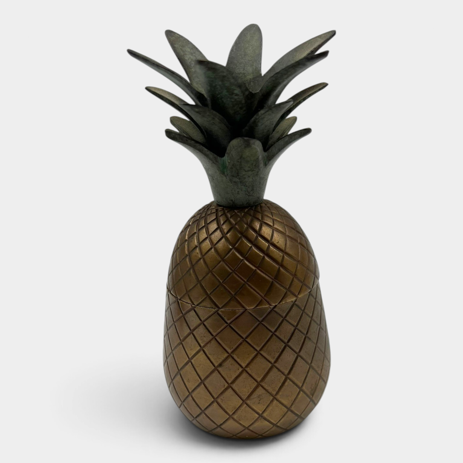 A brass trinket box shaped and textured like a pineapple, with a lift-off lid.