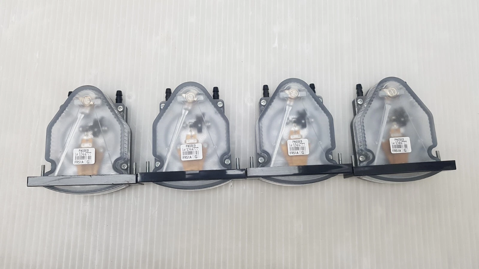 Four FR51A gauges from above showing clear housings, tube taps and PASSED stickers