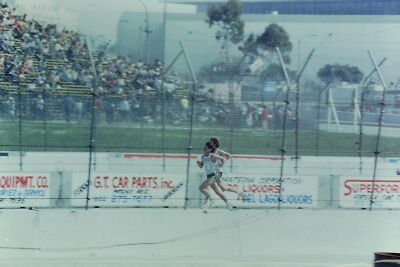 Vintage Found Slide Photo 1970s Runner racing near crowded stadium on a track