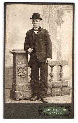 Fotografie Signe Lundström, Ronneby, Heranwachsender im edlen Kostüm mit Melone 