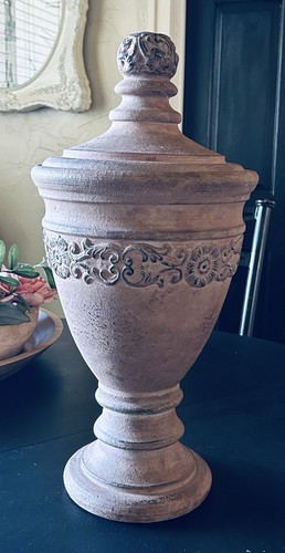 decorative terracotta urn with a distressed, rustic finish and a matching lid