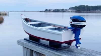 WOODEN SKIFF MODEL, 17.50 INCHES LONG,  WITH MINIATURE BLUE EVINRUDE 18 HP MOTOR