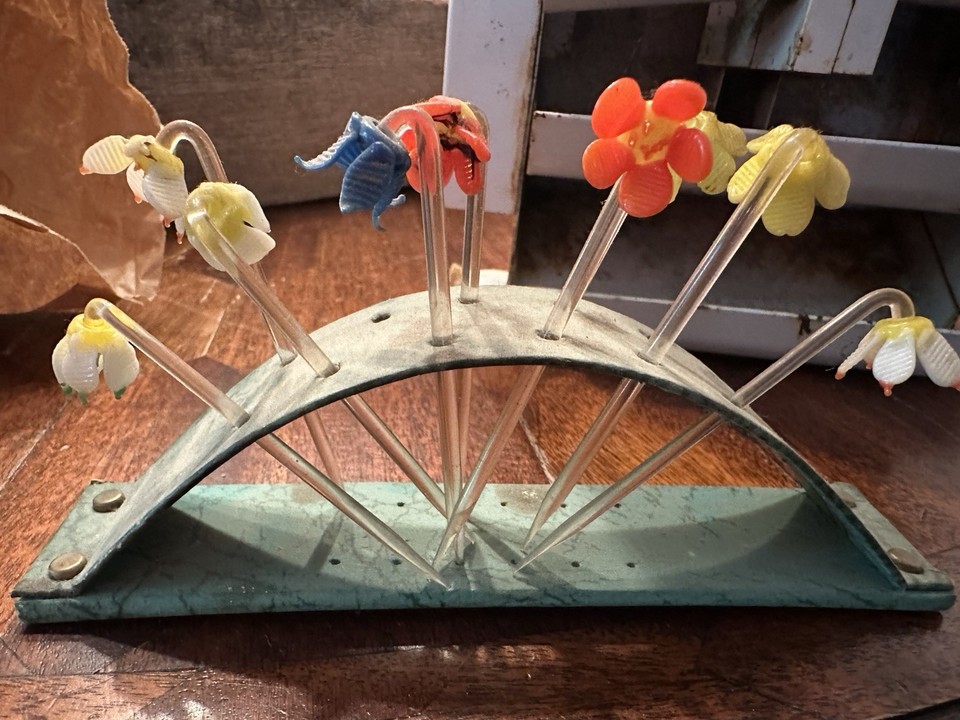 1940s glass flower cocktail picks in their original display case — the kind of barware detail that makes a home bartender feel like they're hosting a Rat Pack party.