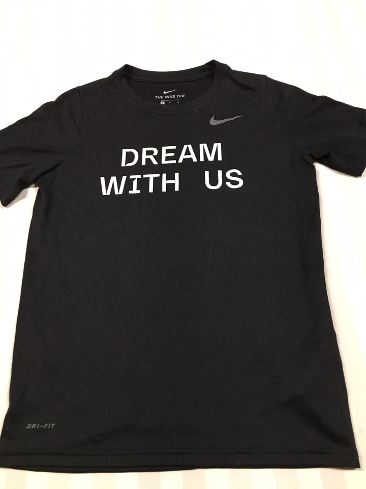 Camiseta Nike Dri-Fit Juvenil Mediana Negra con "Dream With Us" y Logo Gráficos Foto 2 de 4