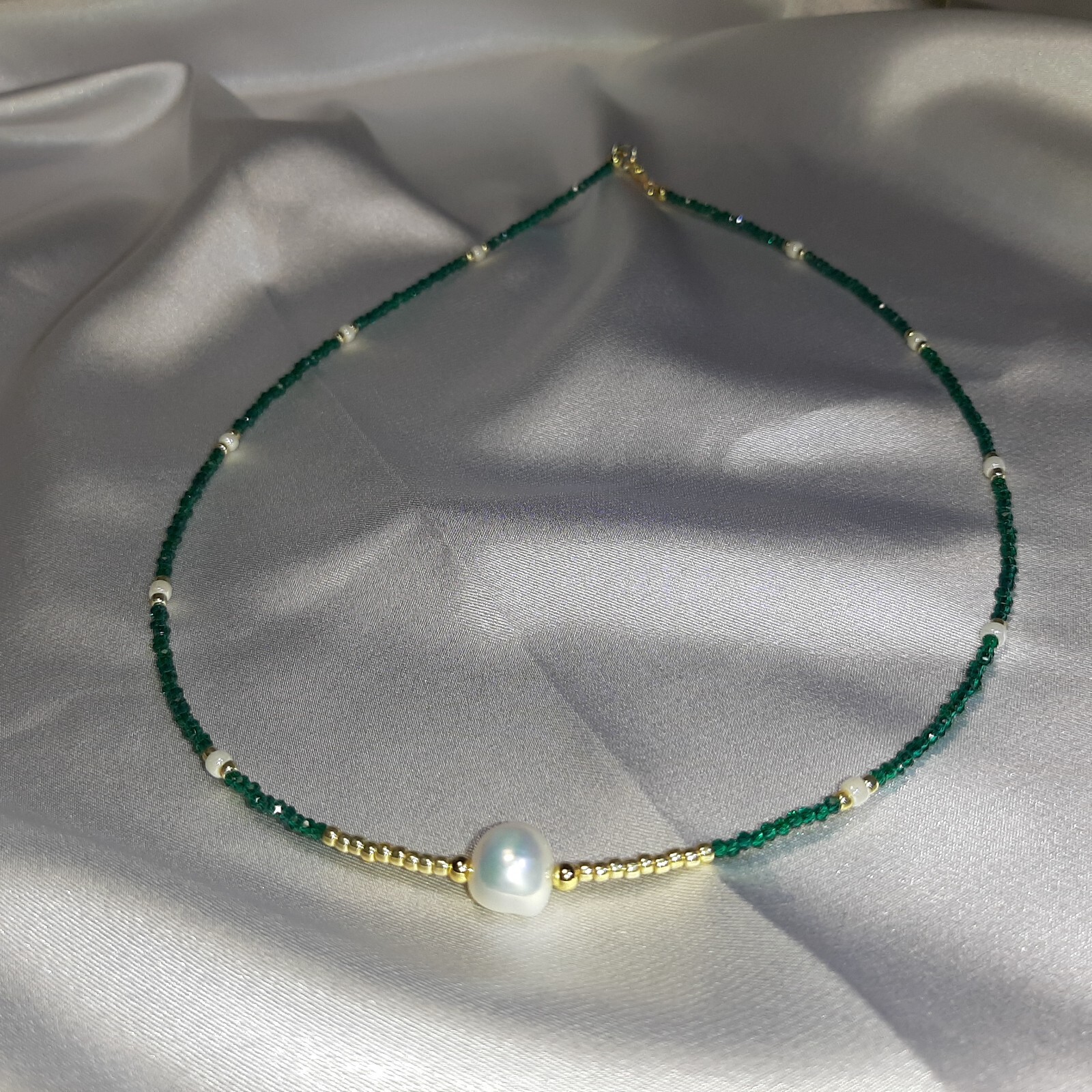 Collier fin en perle de culture et zircon vert pour illuminer vos tenues de bureau