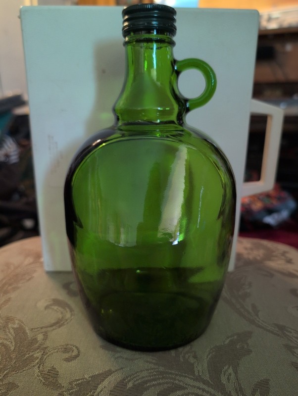 This item is a vintage green glass jug, often referred to as a "dame-jeanne