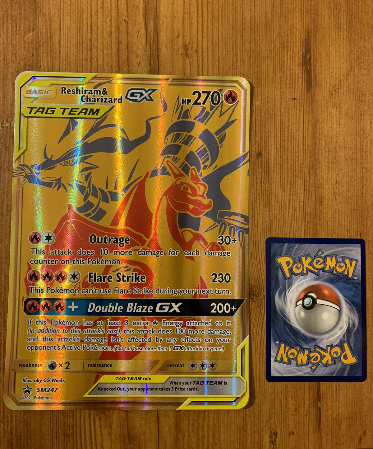 Carta pokemon Reshiram e Charizard GX dourada promo SM247