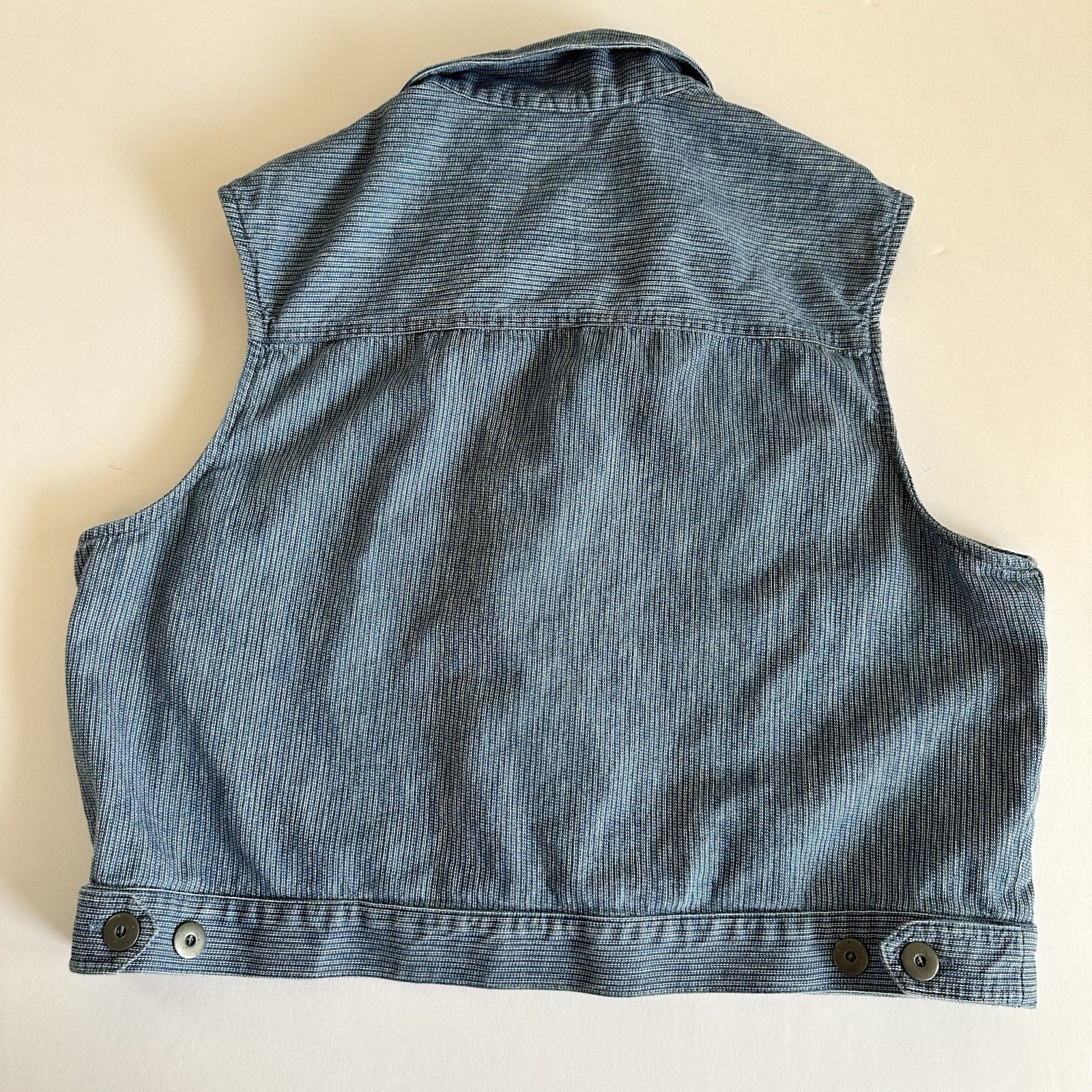Vintage blue cotton denim vest XL with button front, pointed collar, and flap pockets, made in USA.