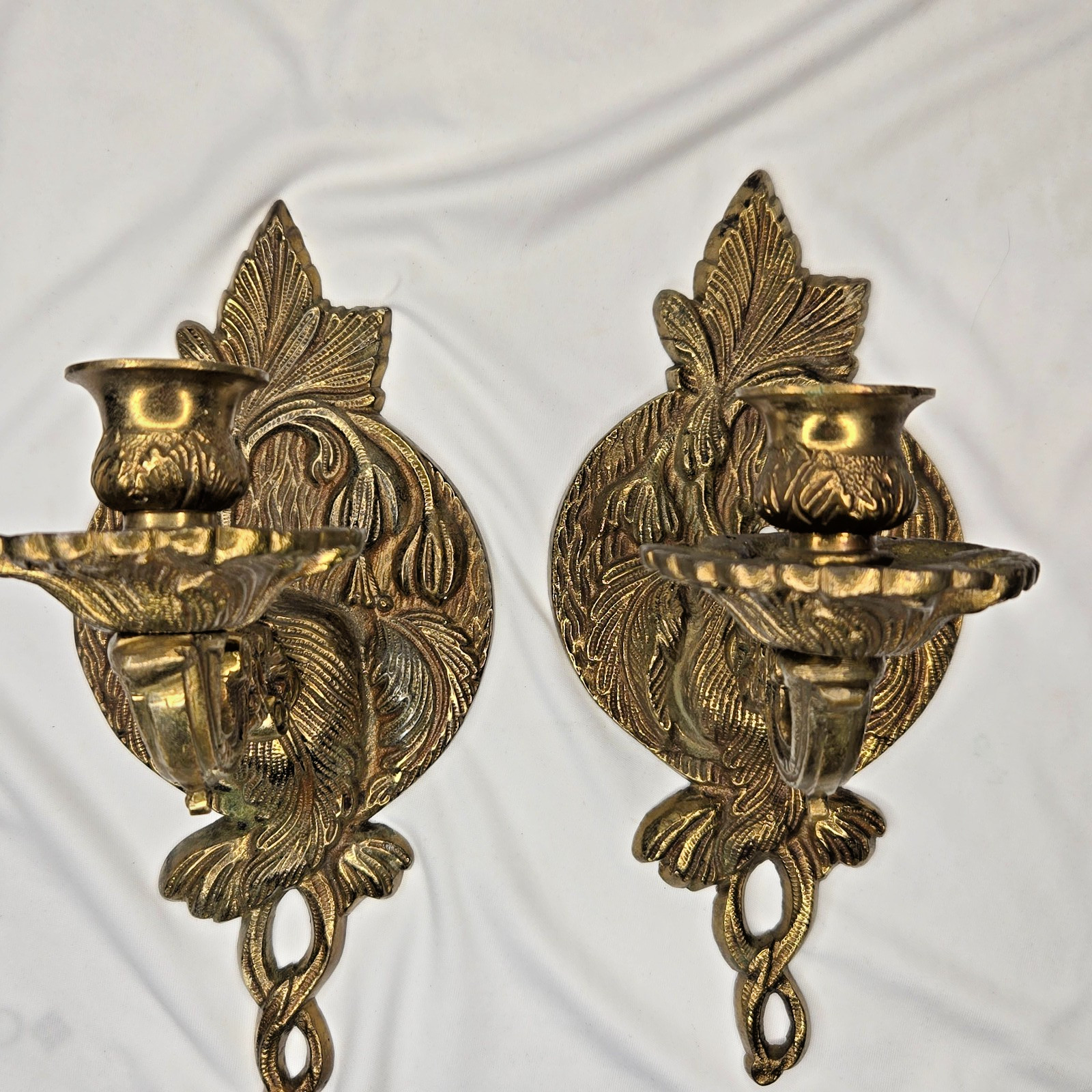 Pair of ornate brass wall candle sconces in rococo scroll design.